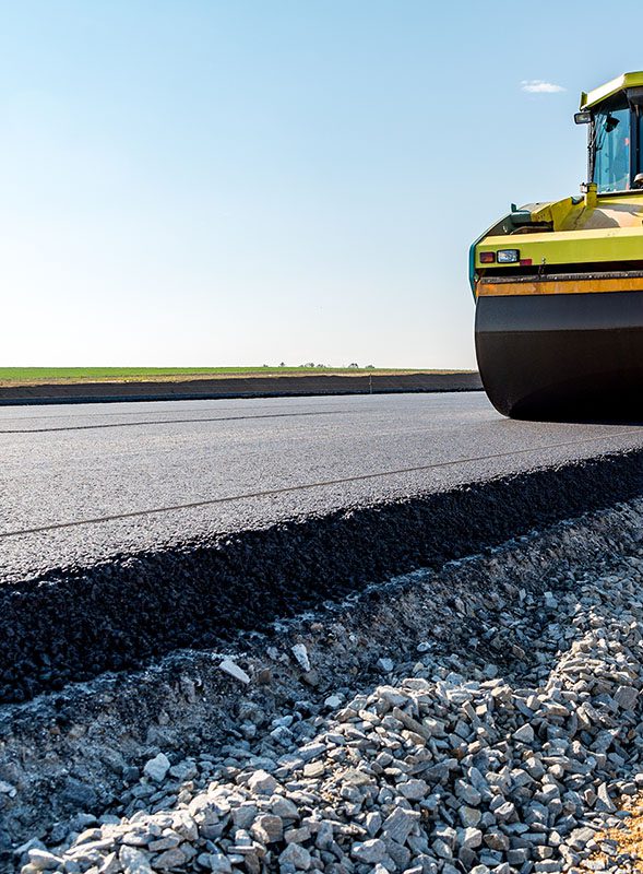 Close-up of a fresh asphalt layer placed over a compacted crushed rock base