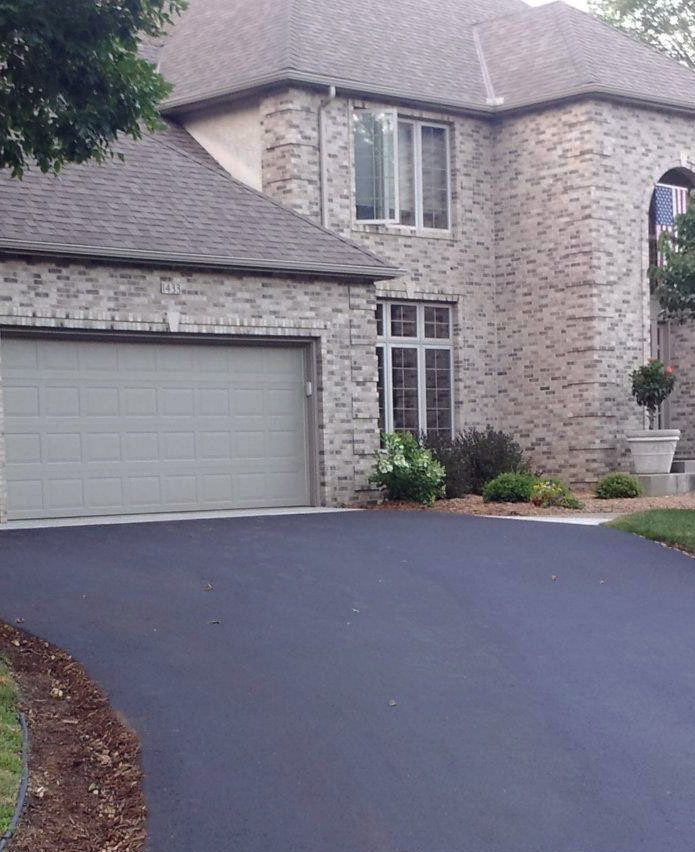 Freshly residential driveway paving in front of a beautiful house to help illustrate Asphalt Paving Hillsboro and Asphalt Resurfacing and asphalt vs concrete