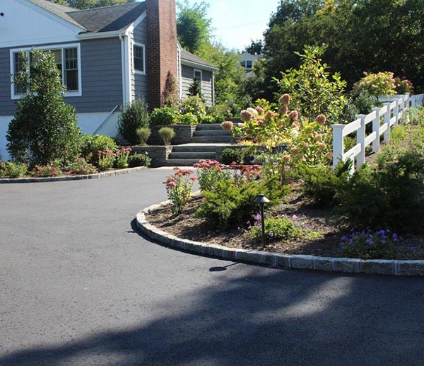 Freshly laid asphalt driveway in front of an updated home to help illustrate best driveway material.