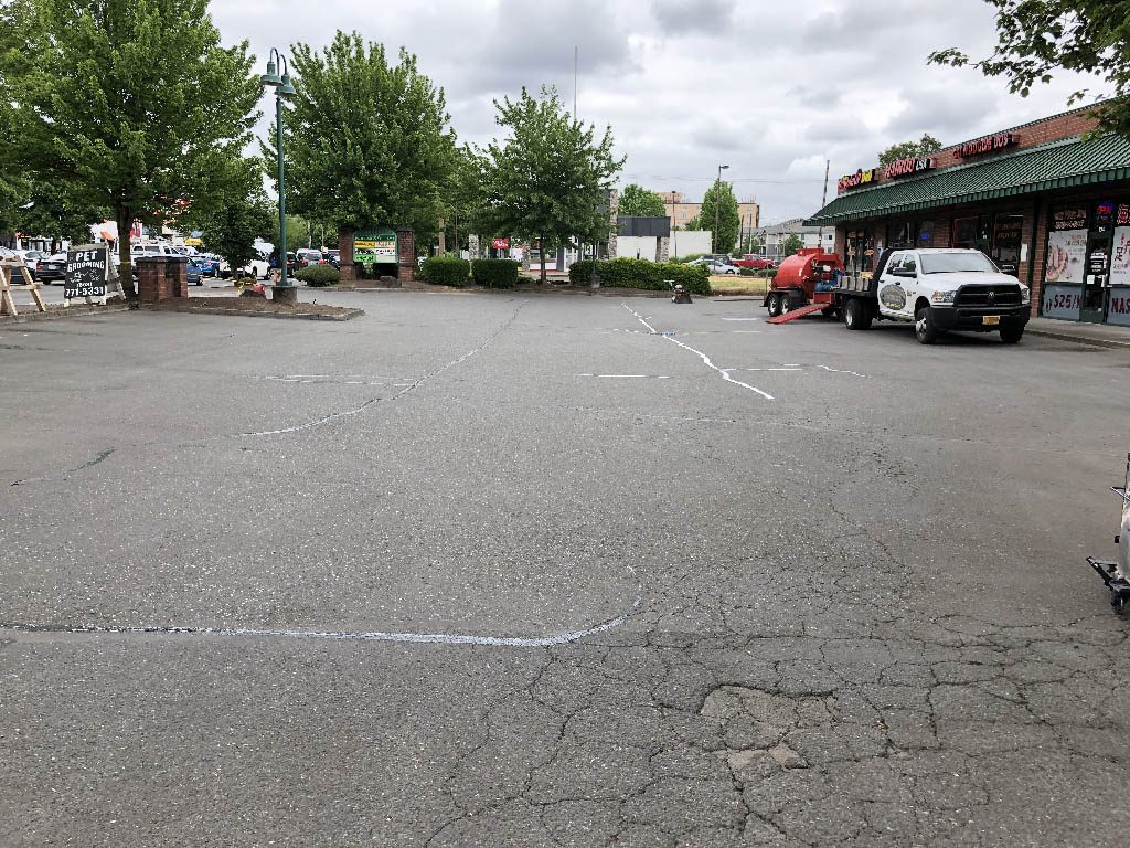 Parking lot with some cracked and crumbing asphalt